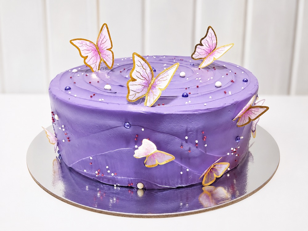 Torta artesanal violeta decorada con mariposas